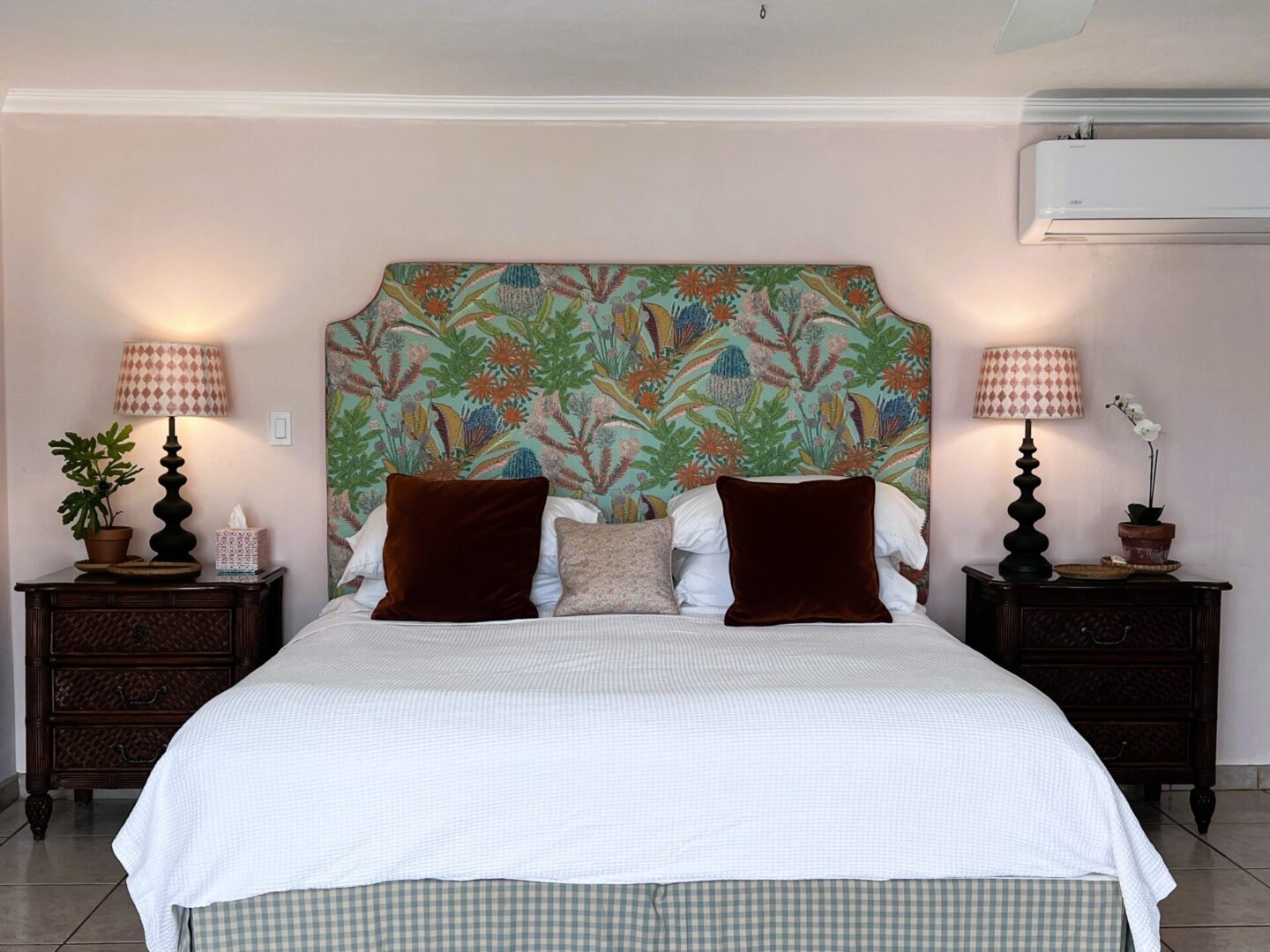 Bed with patterned headboard and bedside lamps